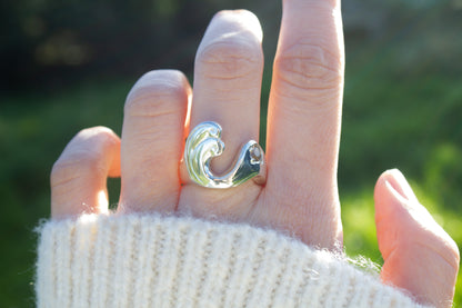 one of a kind sterling silver and spinel sculptural ring handmade Ireland worn on middle finger on a green background