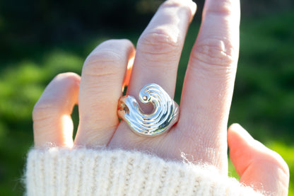 one of a kind sterling silver sculptural ring handmade Ireland worn on middle finger on green background