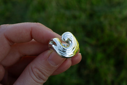one of a kind sterling silver sculptural ring handmade Ireland held in fingers on a green background